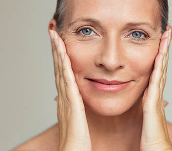 Older woman with beautiful, youn- looking skin smiling.